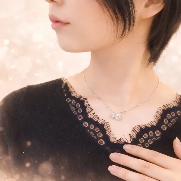 マリコのオーダーメイドネックレス着用シーン。シルバーチェーンにクリスタルボールチャームを組み合わせた完成品。ゴールドボケ背景。